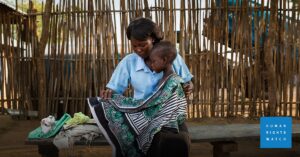 Black woman holding her baby on her lap.